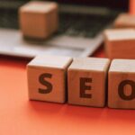 Wooden blocks spelling SEO on a laptop keyboard convey digital marketing concepts.
